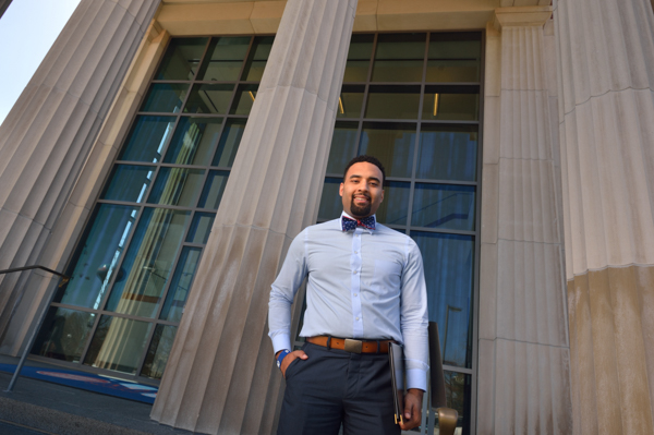 An MDS alumni in front of an academic building. 