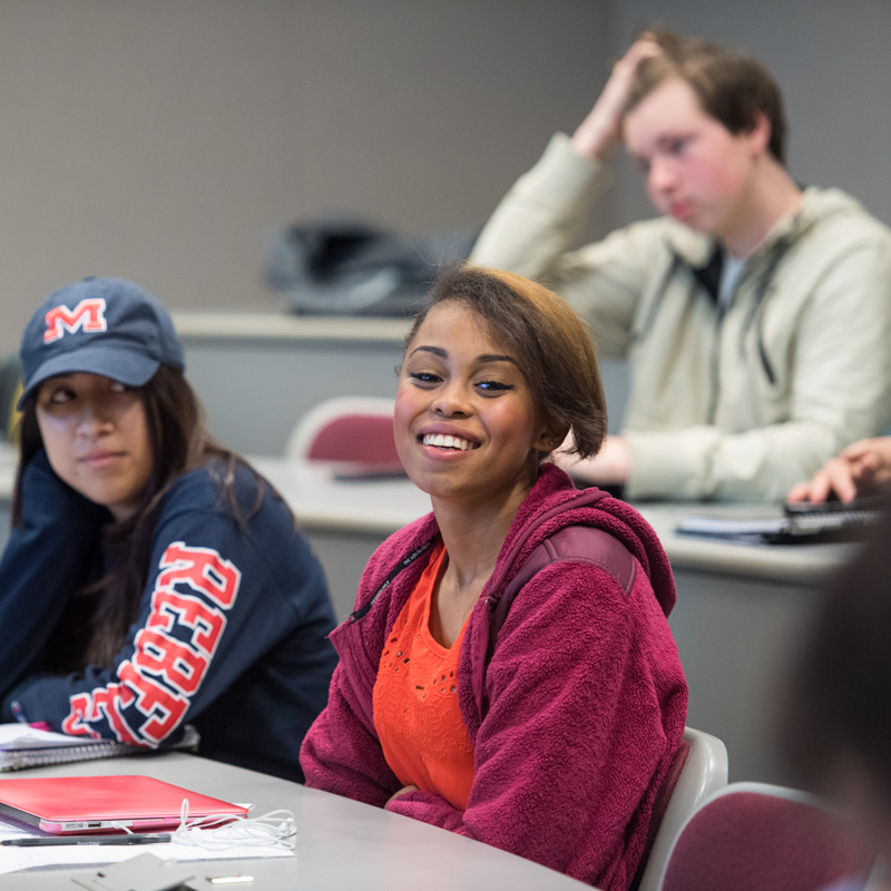 A Freshman Studies student smiles in a classroom.